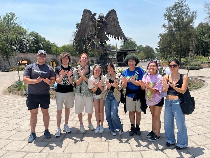 Students in Mexico in front of statue