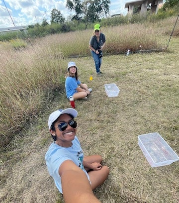students in a grass field doing research